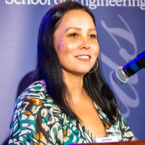 A female scientist sitting in front of a microphone.